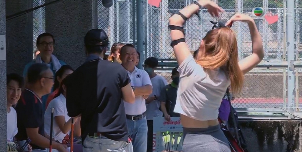 鞏姿希一射完箭之後就即刻向觀眾席比超大心心，而TVB高層曾志偉就正正企喺佢對面