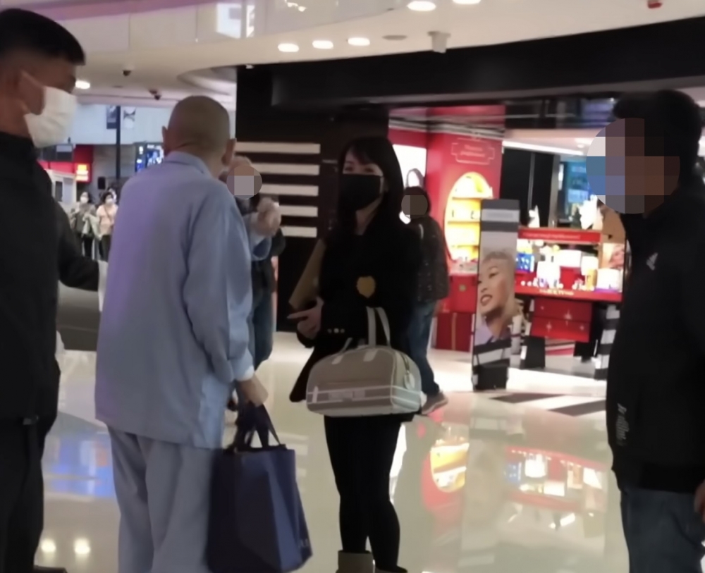 著上淺藍色衫嘅大劉喺保鏢陪同下現身銅鑼灣一個商場,佢以英語吩咐保鏢唔好畀黑衫男人入嚟