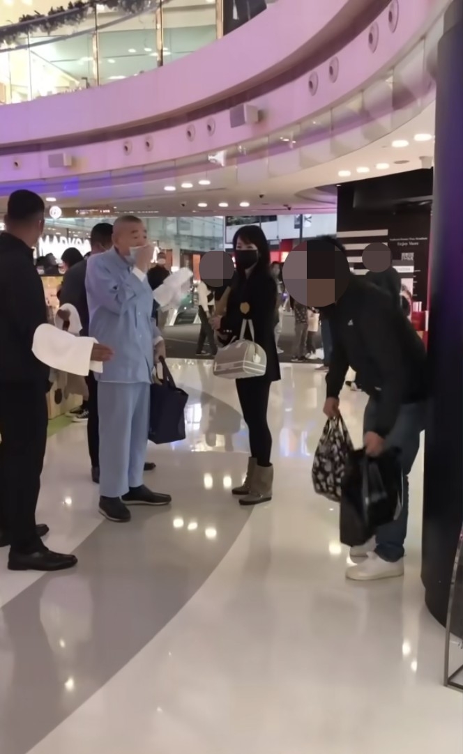 黑衫男子本身喺商場柱附近休息,被大劉指住嚟鬧即慢慢企起身