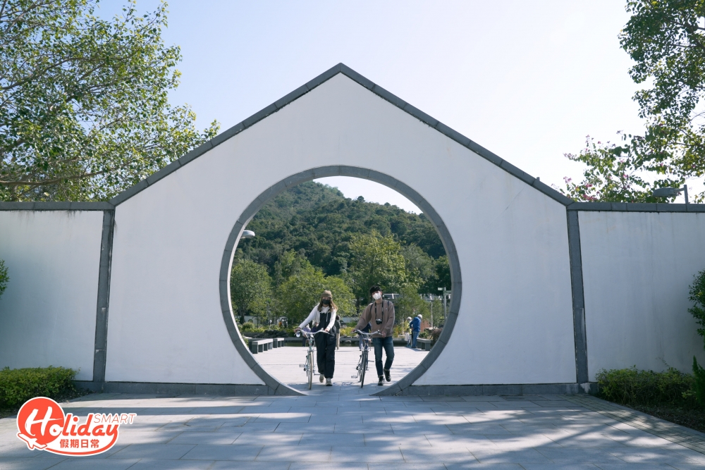 沿著往坑口方向的單車徑，大約踩20分鐘左右，便會來到最後一站—「文曲里公園」，公園最大特色是設計走中式庭園風，以白牆灰頂為主，屬蘇杭建築，園內設有竹棚涼亭、石橋和池塘等，隱藏不少獨有打卡位，特別是滿月形狀的月洞門以及在池塘中央的曲形小橋。