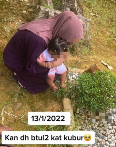 女子在結束儀式後，帶女兒到墳墓前探望丈夫。