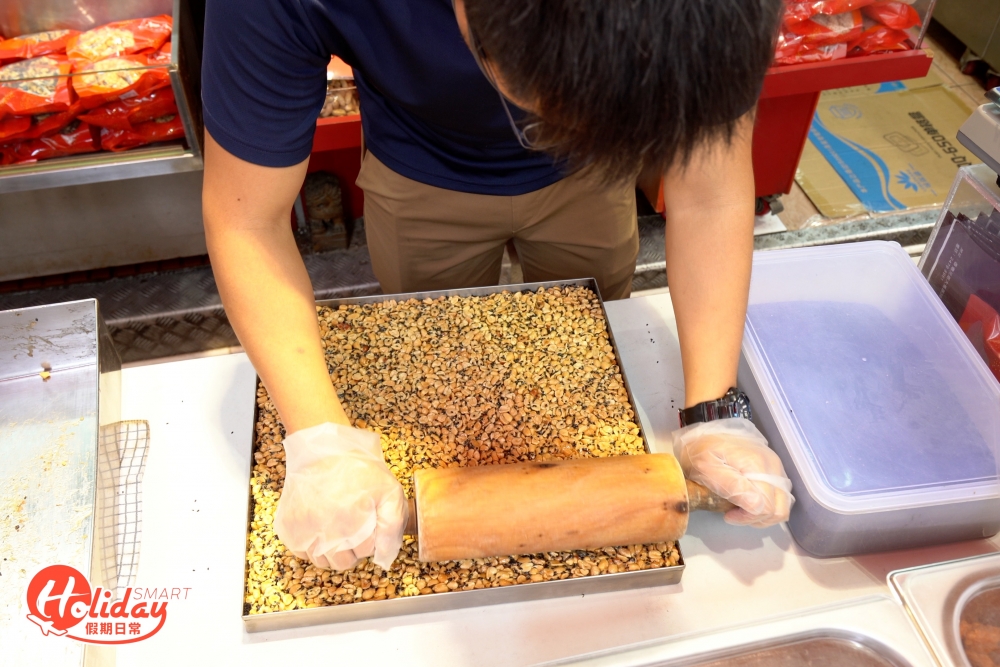 把煮好的糖漿倒進一大盤花生內,拿起鏟子不停混和糖漿及花生,過程看似輕易,其實相當費勁,手腳慢一點糖漿很快冷卻,之後再將一盤盤花生糖切成一口Size,粒粒花生糖都是心機之作。