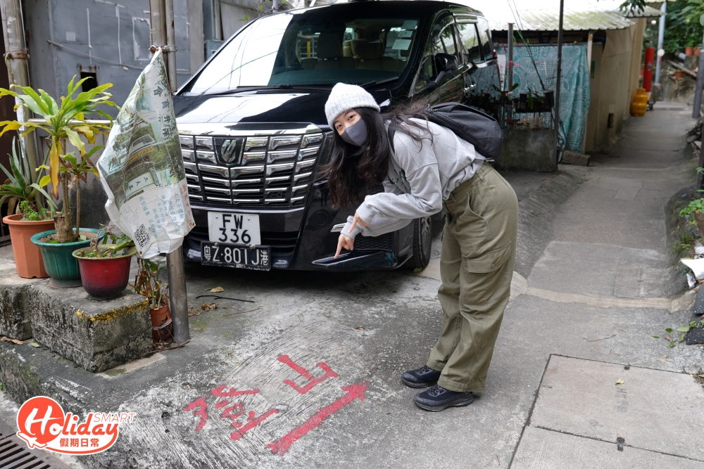 經過屯門公路橋底，右側為裕記停車場，旁邊小路有「登山」紅字，上梯級後也有不同的紅字標記引路。