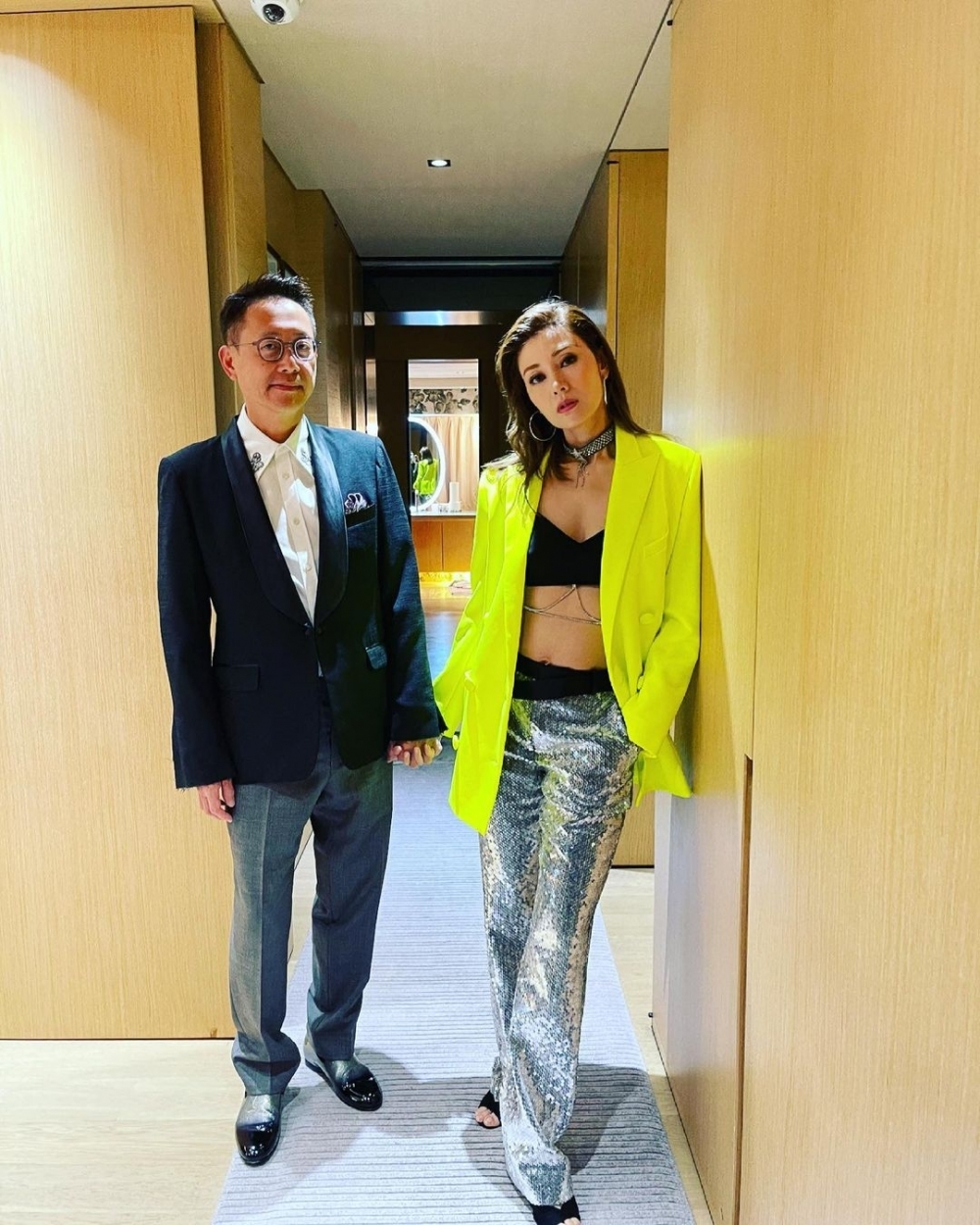 李嘉欣著上Bra Top配銀鏈，下身著銀色珠片褲、外面再搭螢光黃外套