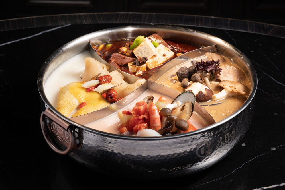 花月宮特色四格湯底,包括麻辣、花膠醉雞、黑松露野菌及番茄海鮮。