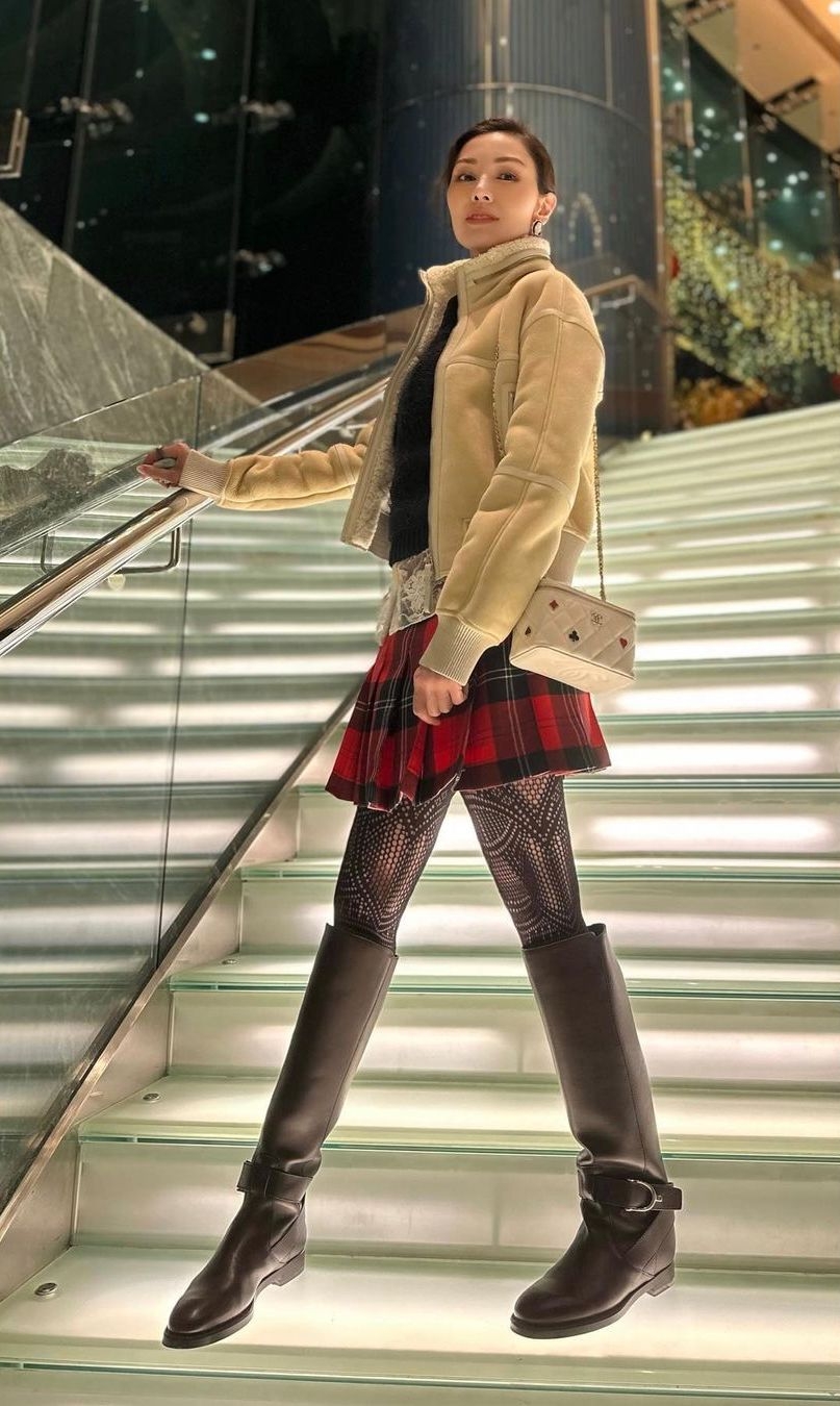 杏色外套配紅色格仔短裙，黑色長靴內襯花紋褲襪