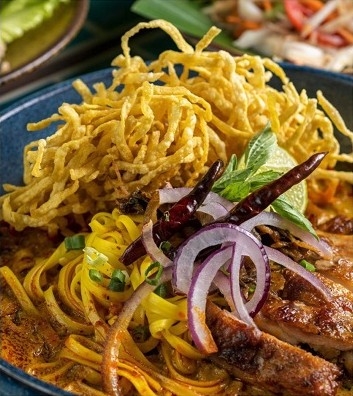 泰北咖喱金麵散發住椰漿咖喱香氣與炭烤雞肉風味。