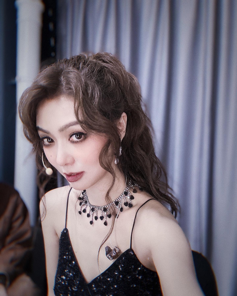 薛凱琪留言：「Darker eyes vs sleepy eyes」，相中Fiona將一頭長曲髮紮成馬尾，妝容濃艷，相信係舞台妝容。