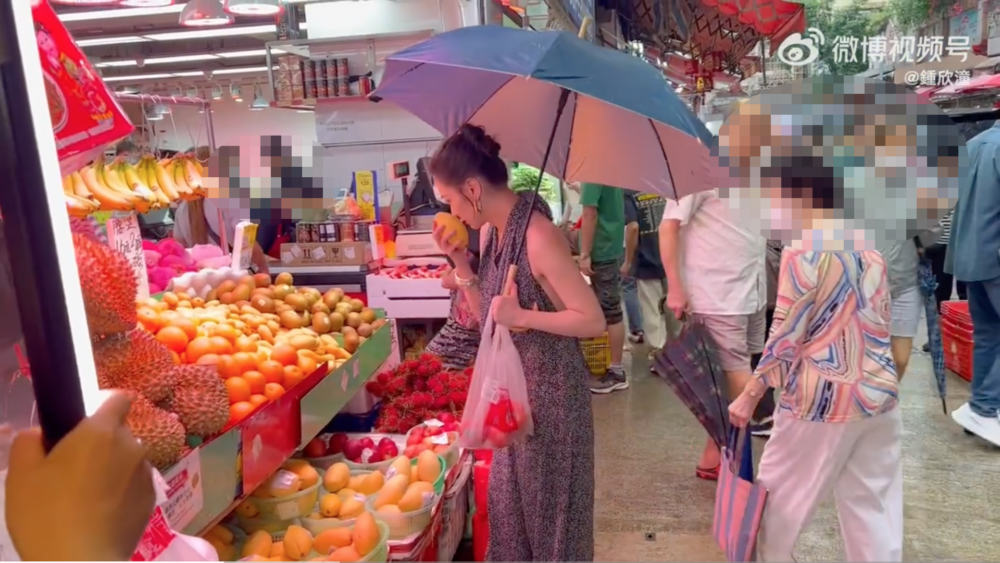 佢又去生果舖揀生果，阿嬌更拎起個芒果聞。 