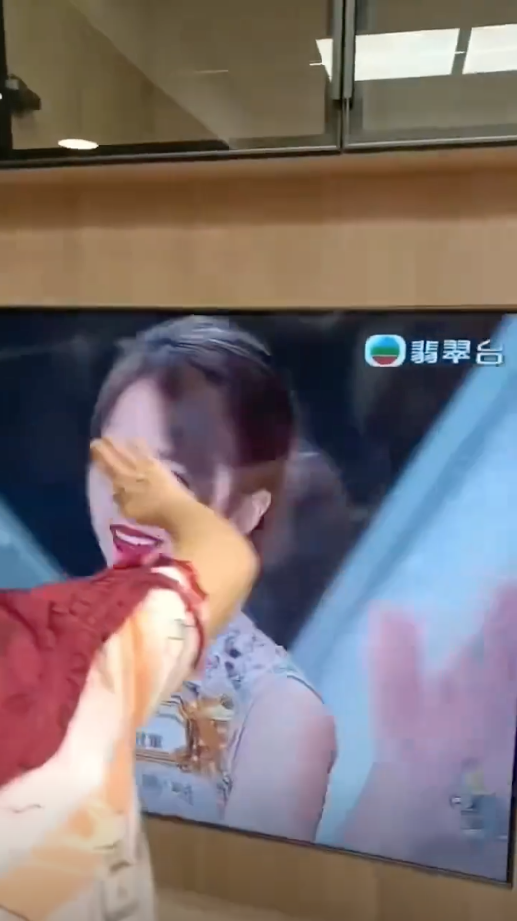 有一位中年婦女更激動到衝上前用手觸摸電視機