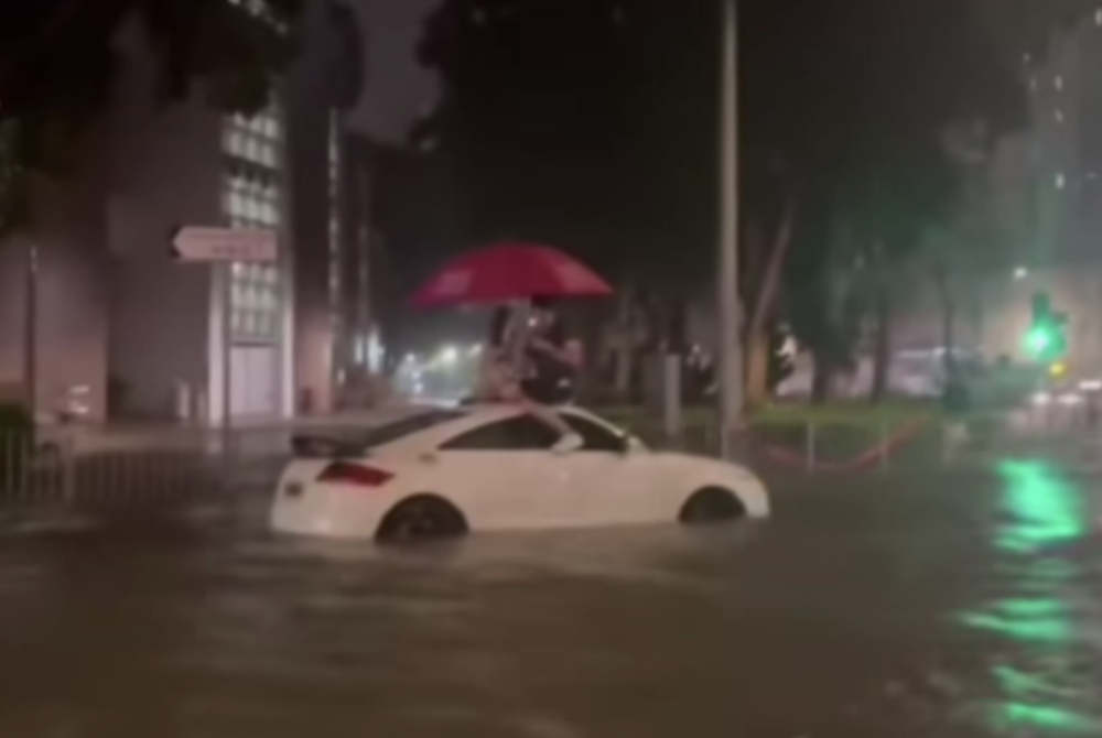 Facebook群組「香港風景攝影會」有網友就影咗黑色暴雨下有一對情侶面對水浸只能爬上車頂。