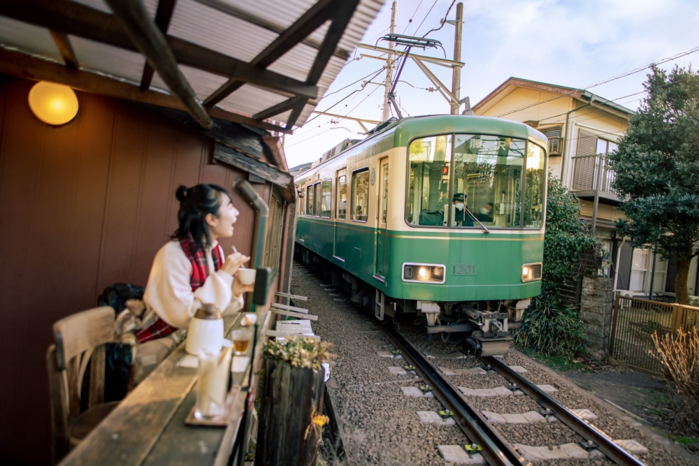 位於江之電腰越站前的咖啡廳兼酒吧「SHONANPHOTO CAFE」，從店內望出去可以近距離看到行駛在眼前的江之電！