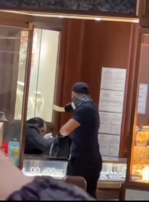 片中袁偉豪蒙面持刀走入珠寶店打劫,被現場很多人圍觀及持手機拍攝