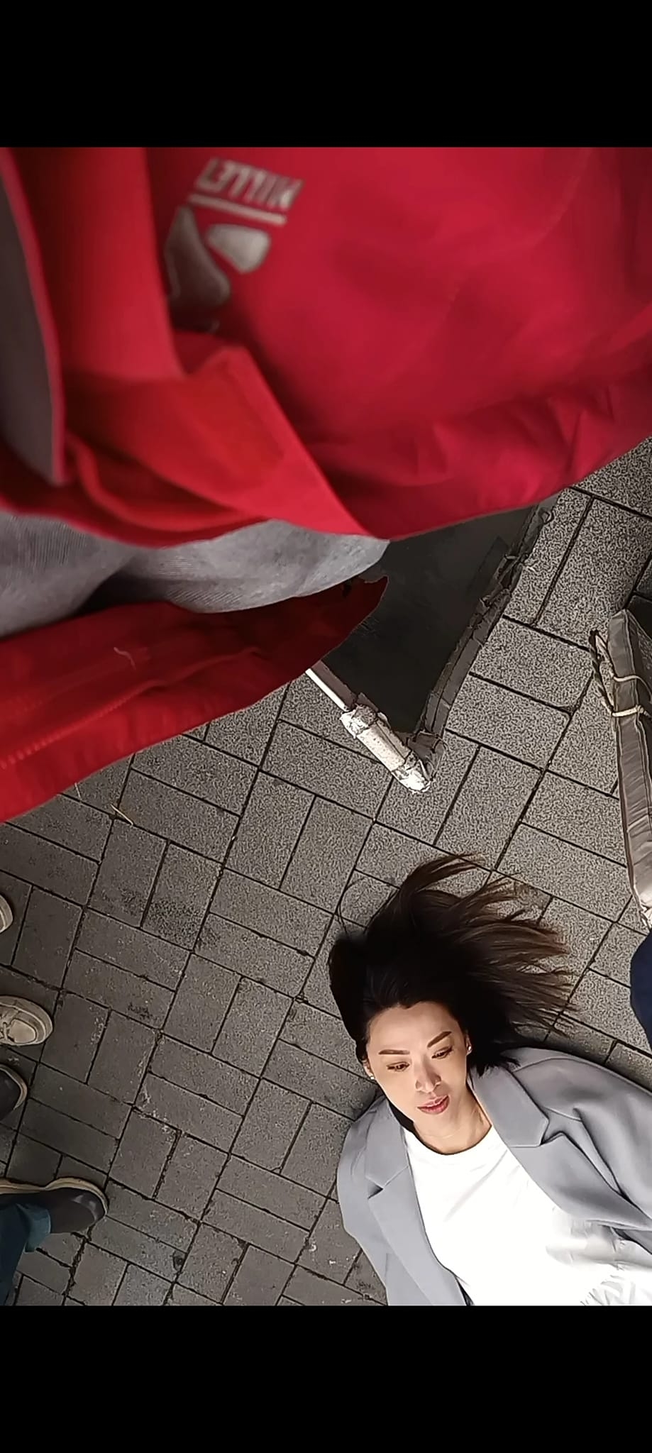 她疑似暈倒在地上,而途人和她的距離也很近。