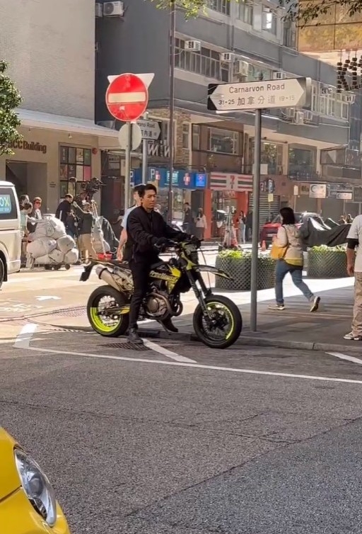 片中可見袁偉豪當天騎著電單車停靠在路邊