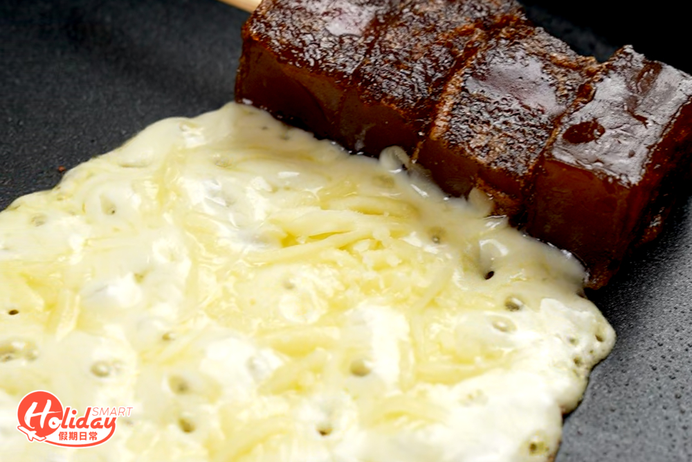 在鍋中灑上適量的芝士碎，等待起司充分融化。