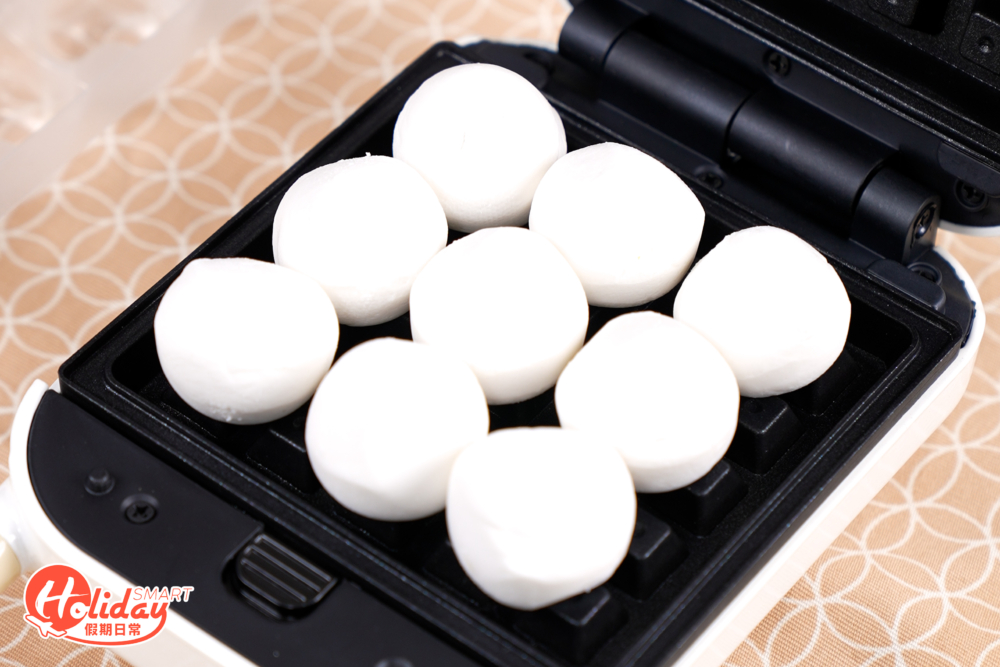 先將鬆餅機預熱，然後將湯圓平鋪在鬆餅機上