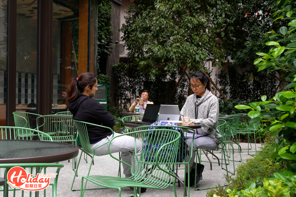 新店以咖啡店酒吧的模式經營，分為開放式酒吧區和露天用餐區，露天用餐區環繞著綠樹，並配有條紋太陽傘，讓人感到舒適悠閒。