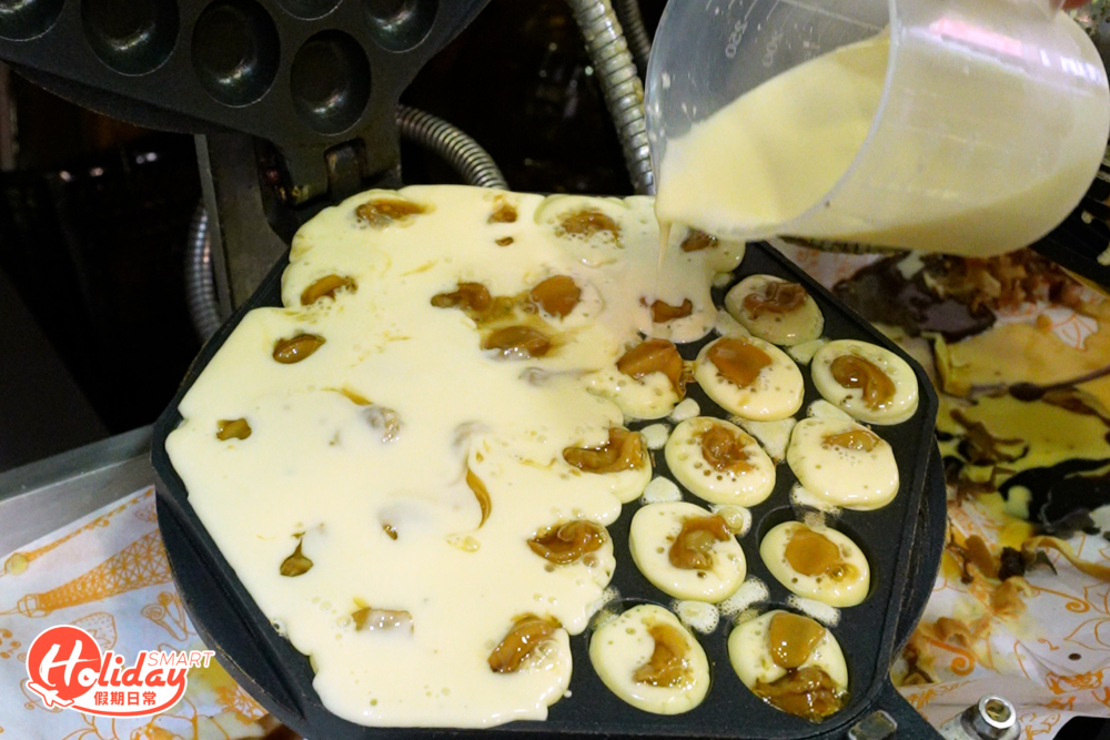 店員將一粒又一粒鮑魚倒進蛋漿中，每粒只有指頭大，非常迷你。