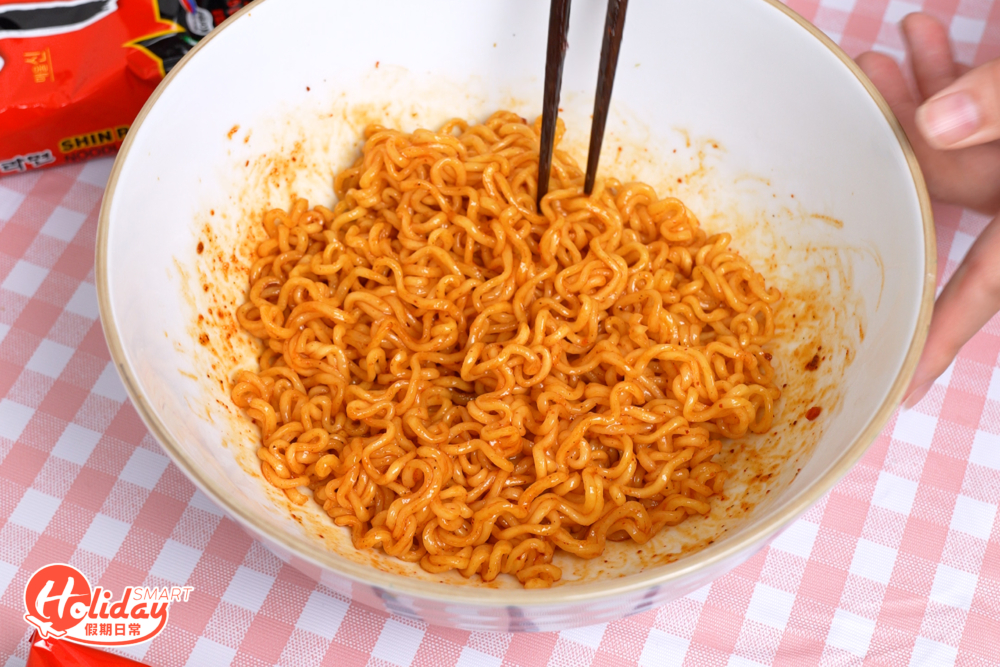把麵倒入碗中，再攪拌麵條和調味粉。