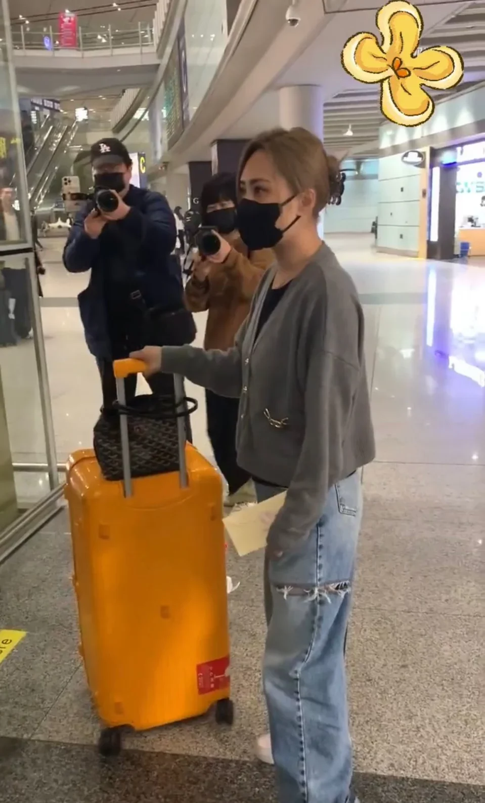 阿嬌當日在沒有工作人員陪伴下，獨自推著行李喼和手袋正等待電梯