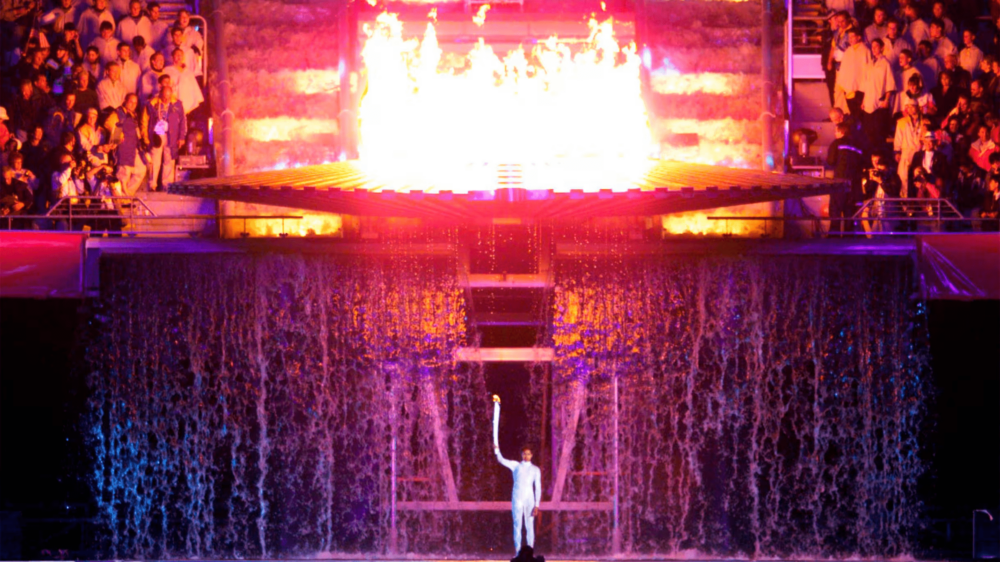 田徑短跑名將「Cathy Freeman」在2000悉尼奧運身穿銀色連體防水服，在四周瀑布飛瀉的水中點燃主火炬，「水火相融」的經典畫面堪稱一絕！