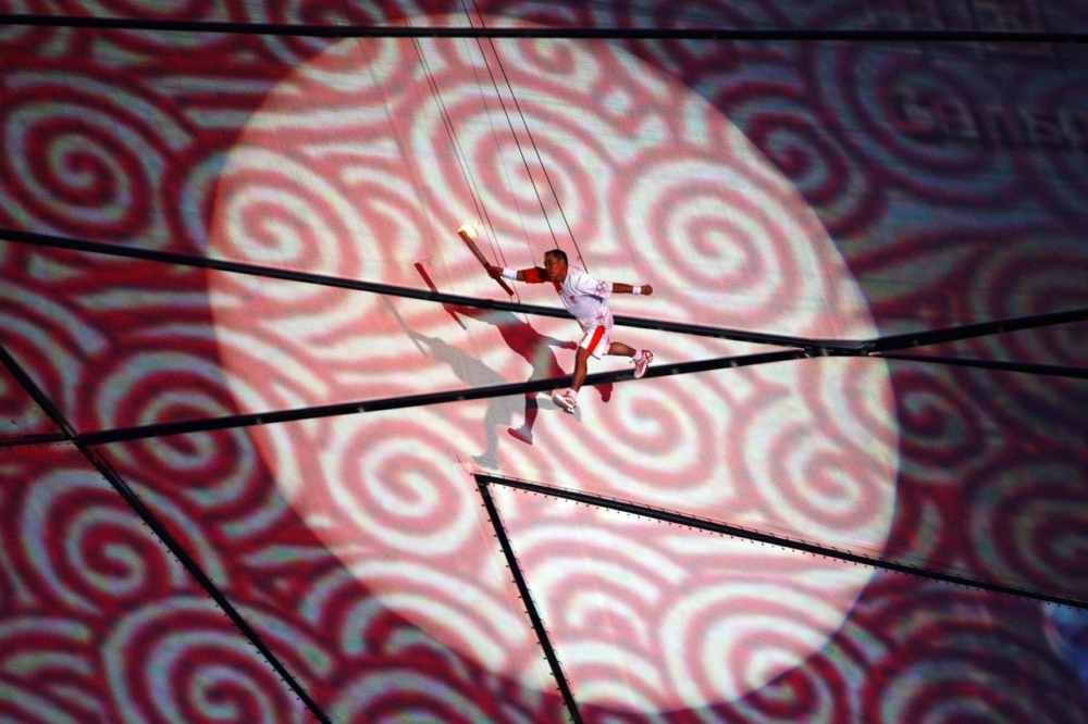 前體操世界冠軍「體操王子」李寧在2008北京奧運以空中飛人之姿亮相，手持火炬，沿著投射出來的中式卷軸凌空繞場一周，並最後點燃火炬台的引線！