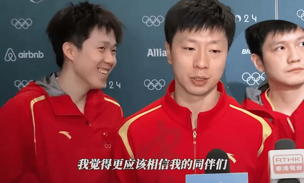 樊振東和王楚欽就在馬龍身後相視而笑