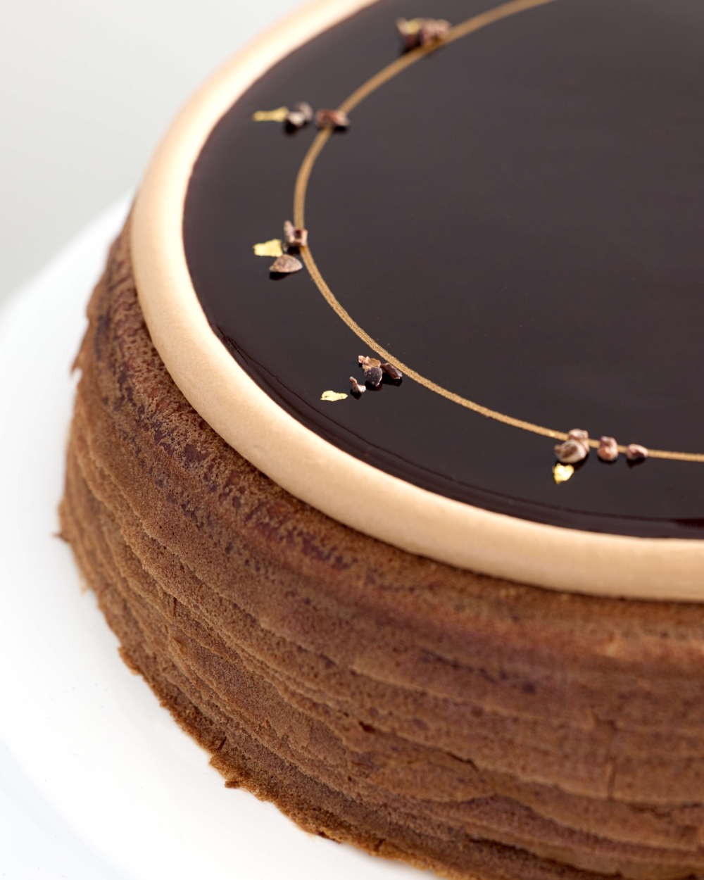 頂層更以 Valrhona朱古力鮮忌廉圈、奢華的金箔與可可豆碎片作點綴,外型高貴。