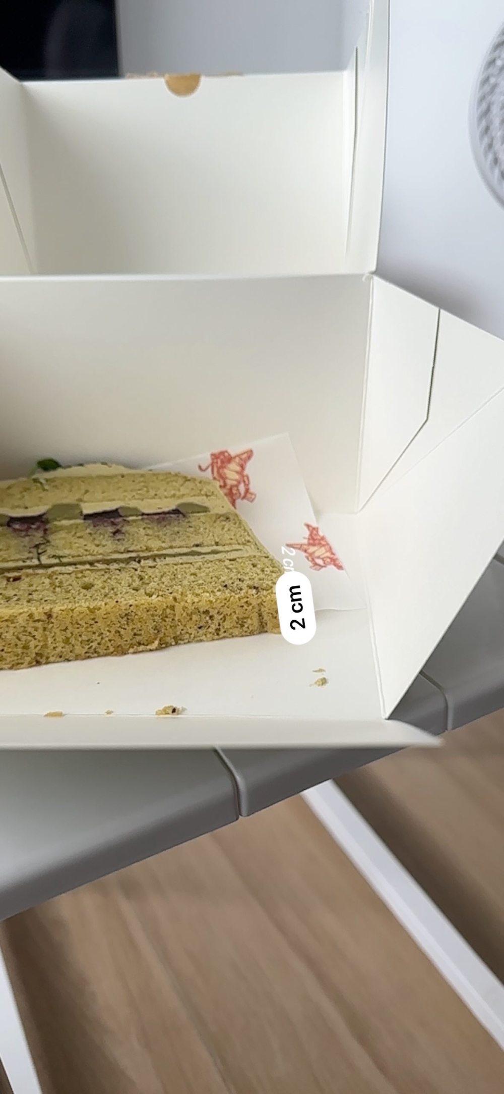 盛載蛋糕的大紙盒內，蛋糕只有薄薄一片