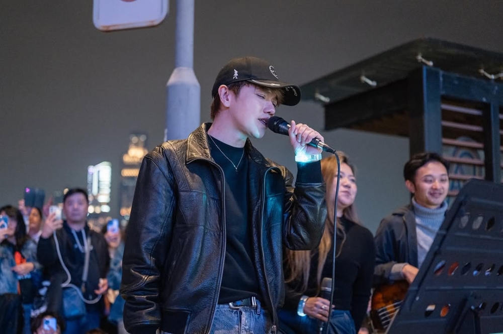 街頭樂隊The Flame日前於灣仔海傍表演，期間戴上黑色Cap帽的張敬軒突然驚喜現身表演