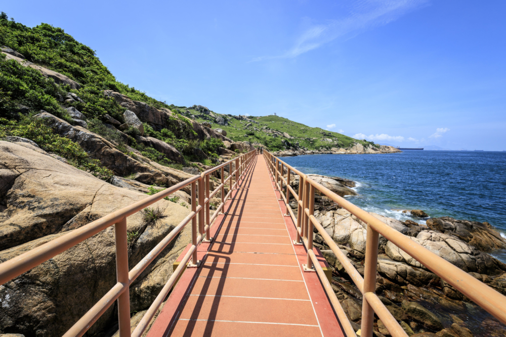 蒲台島橋是一座粉紅色沿海橋樑，連接奇岩與壯麗海景，鮮豔色彩在藍天碧海映襯下成為行山途中浪漫打卡熱點，適合情侶或朋友拍攝氛圍感美照～