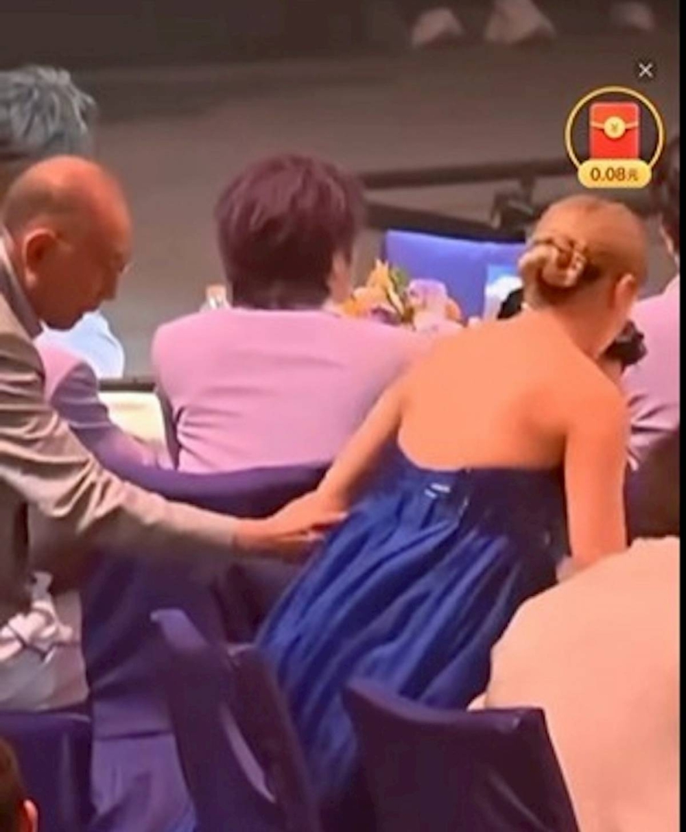 與此同時，英皇老闆楊受成就站起來，走到容祖兒身邊與她調位。