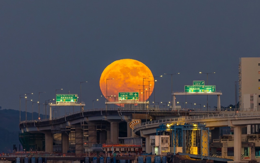 利用「透視壓縮」效果，就會影出「巨月壓頂」嘅壯觀畫面