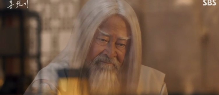 這股光芒跑到了陷入昏迷的成祖(趙成夏 飾)身邊,而這股神力的化身正是監獄裡的那位老朽