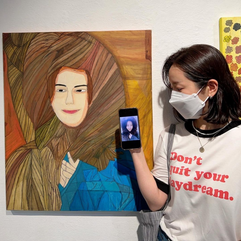 韓志旼拿著照片和作品留下認證照