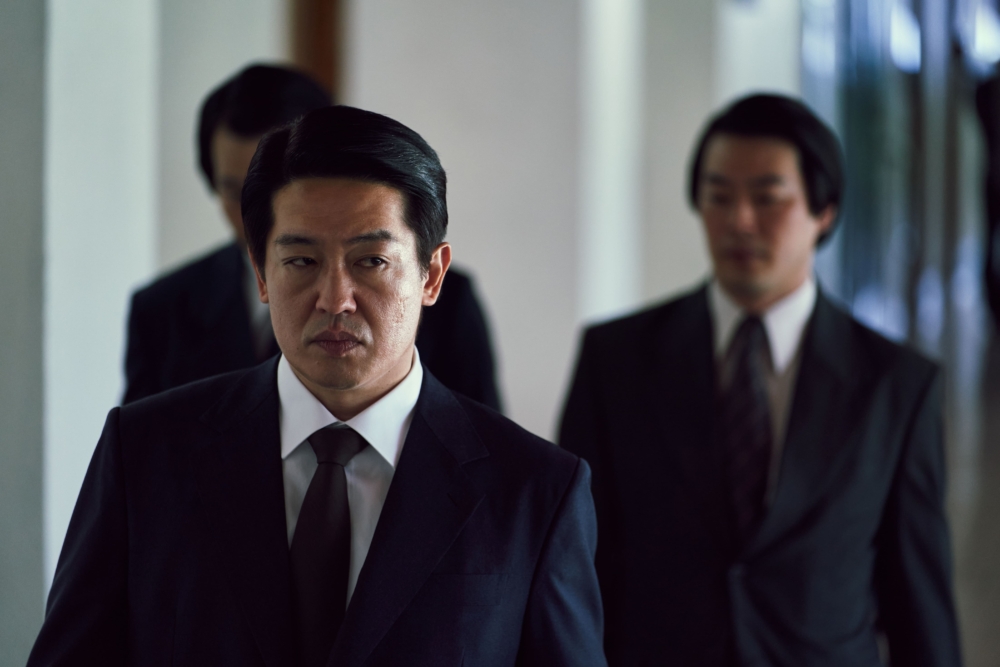 許成泰則飾演組長「鄭彩萬」